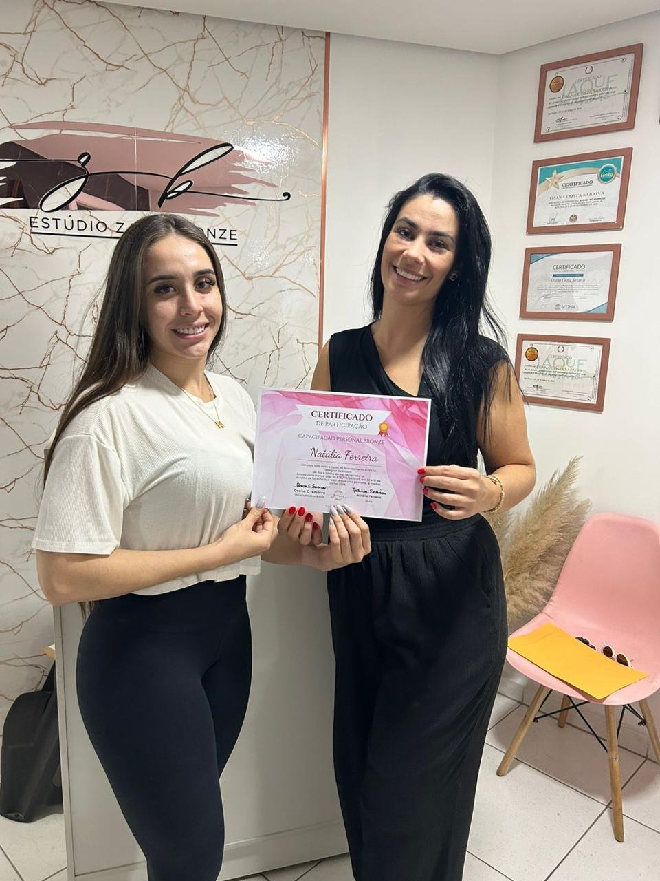 Aluna Natália com o certificado do curso de bronzeamento